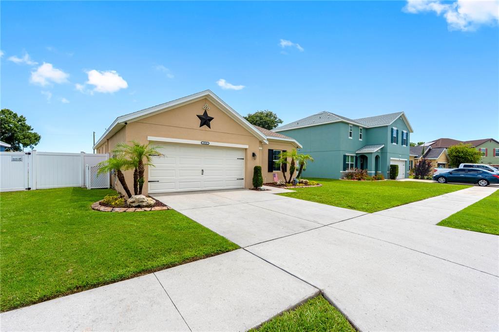 A tan single-story house features a two-car garage, a front lawn, and a paved driveway — 3518 SAN MOISE PLACE, PLANT CITY, FL