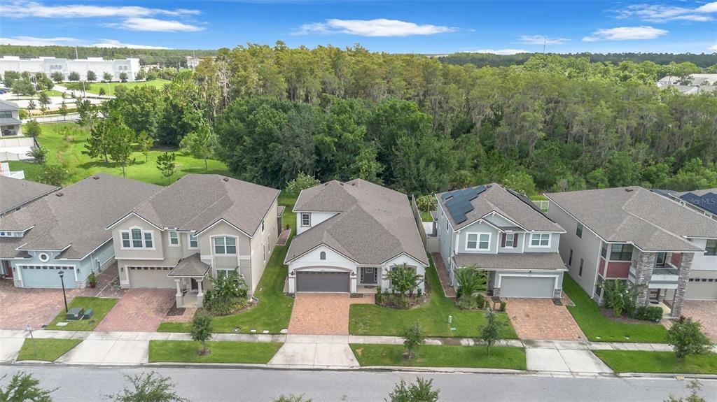 An aerial view shows a row of suburban houses with paved driveways and grassy lawns — 2285 CENTERRA LOOP, KISSIMMEE, FL