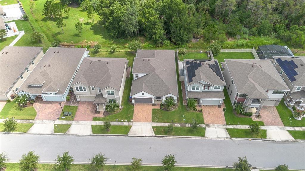 An aerial view shows a row of suburban houses with paved driveways and green lawns — 2285 CENTERRA LOOP, KISSIMMEE, FL