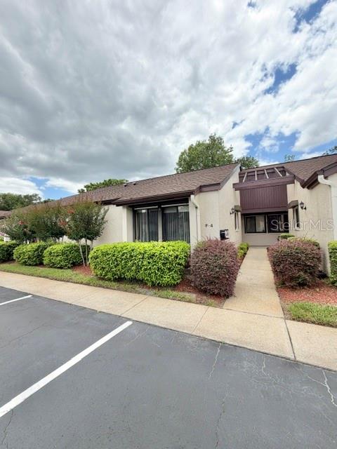 A single-story residential building with a brown roof and a paved parking area in front — 101 GRAND PLAZA DRIVE UNIT F4, ORANGE CITY, FL