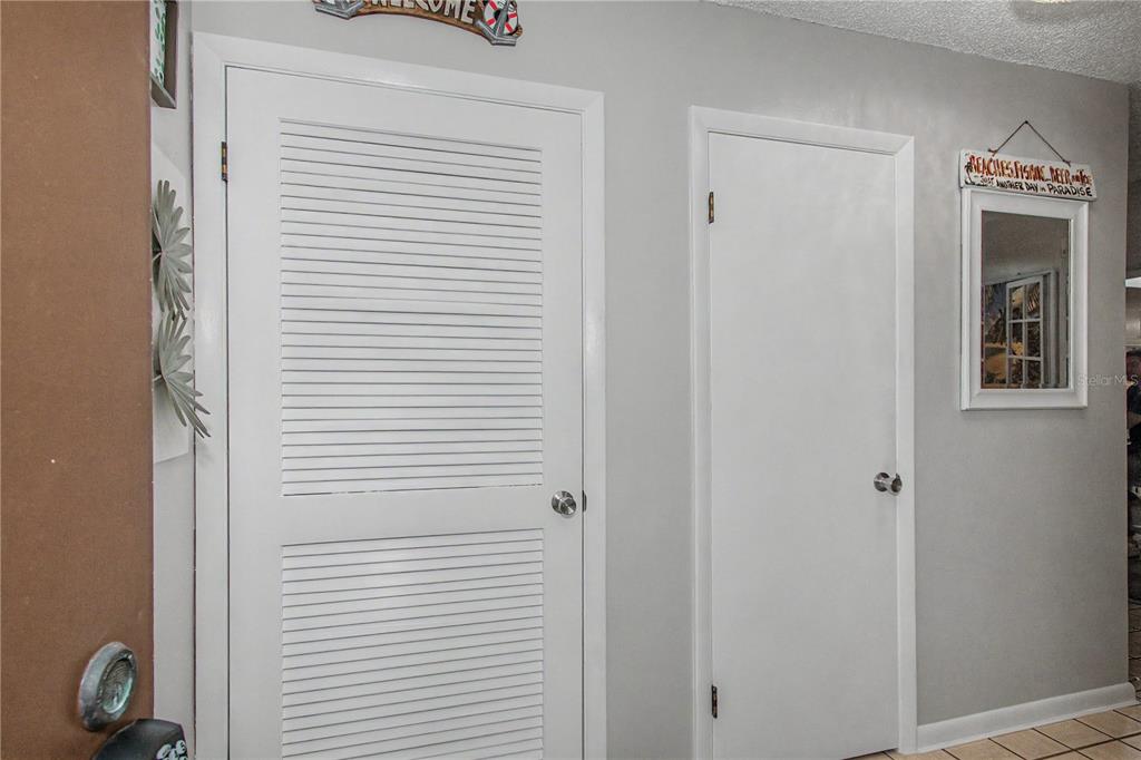 A hallway features a louvered closet door, a solid interior door, and wall decor — 510 SILVER COURSE UNIT B, OCALA, FL