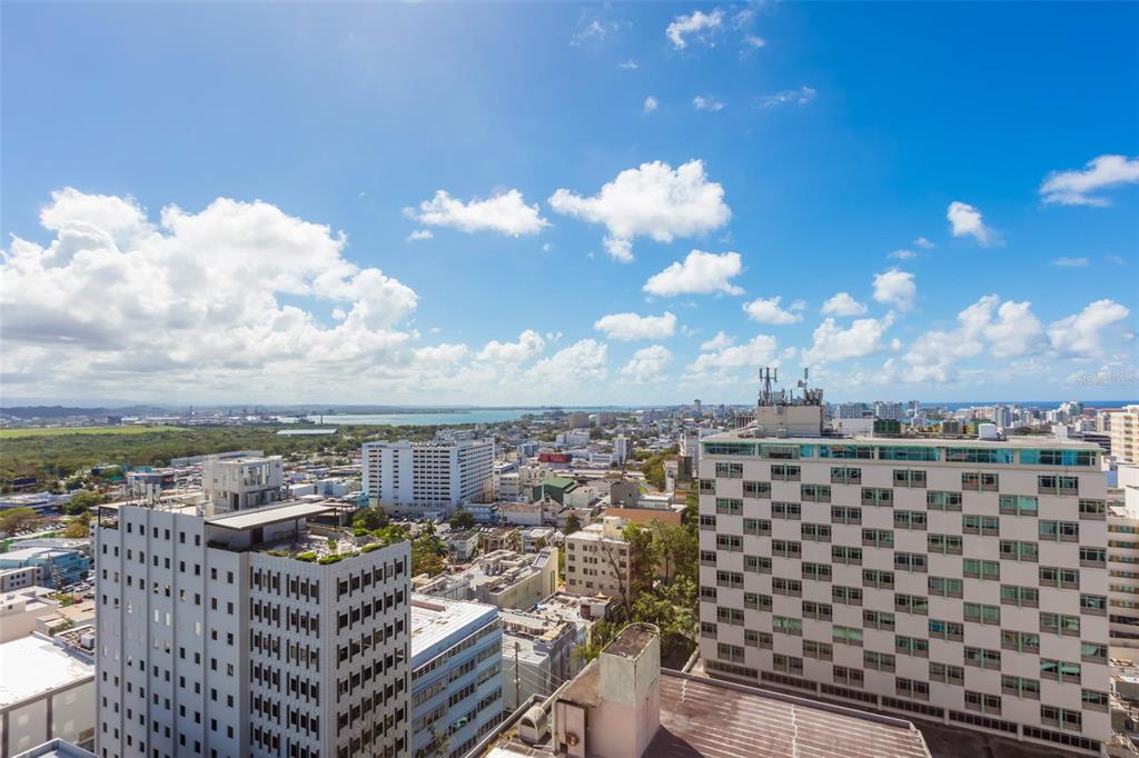 An elevated view of a city skyline with multiple high-rise buildings under a blue sky — C. Bolivar COBIANS PLAZA AVENUE UNIT 21, SAN JUAN, PR