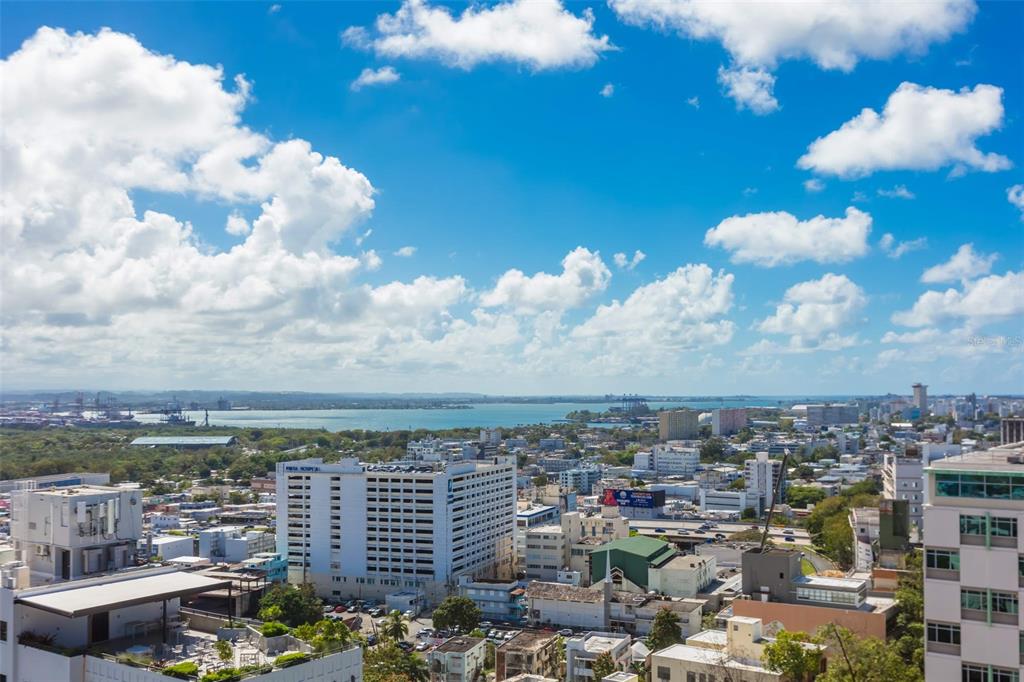 An elevated view of a city skyline with a large white building and a bay — C. Bolivar COBIANS PLAZA AVENUE UNIT 21, SAN JUAN, PR