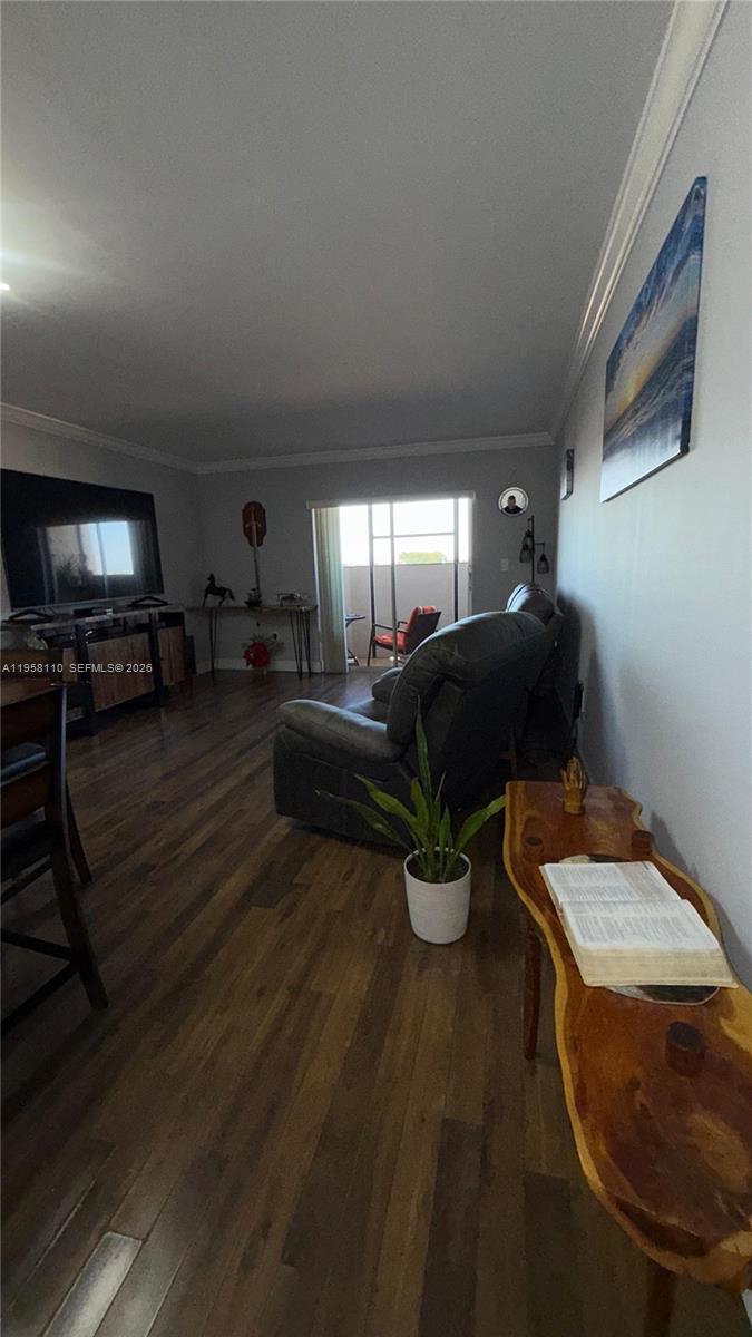 A living room features dark wood flooring, a leather recliner, and a sliding glass door — 1075 W 68th St # 403, Hialeah FL 33014, HIALEAH, FL