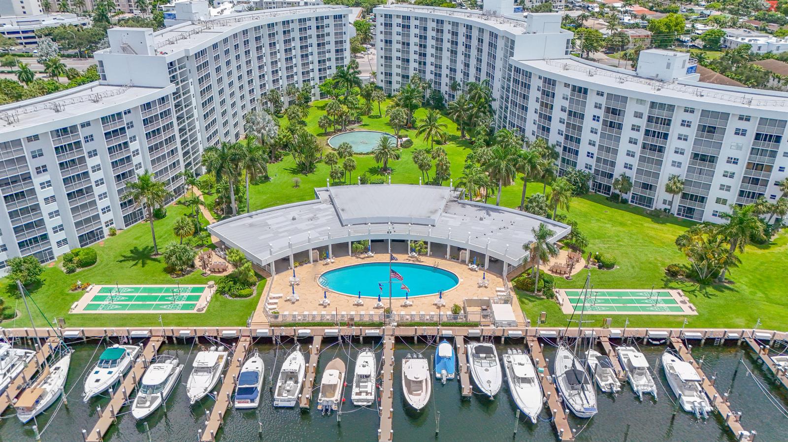 An aerial view shows a residential complex with a pool, courtyard, and private boat slips — 2731 NE 14th St Causeway # 115, Pompano Beach FL 33062, POMPANO BEACH, FL