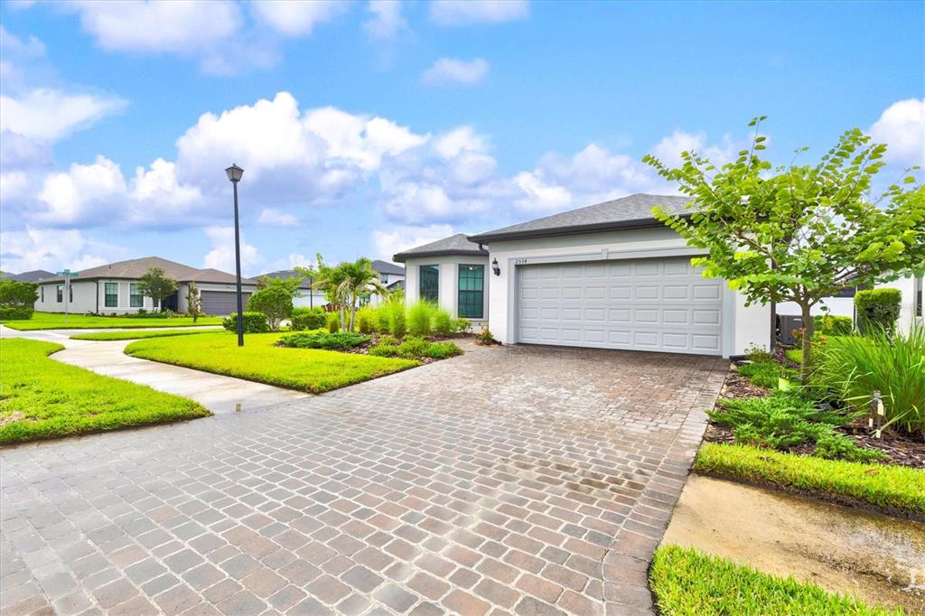 A single-story house with a paved driveway, a two-car garage, and a landscaped front yard — 2534 GABEL OAK DRIVE, NORTH PORT, FL