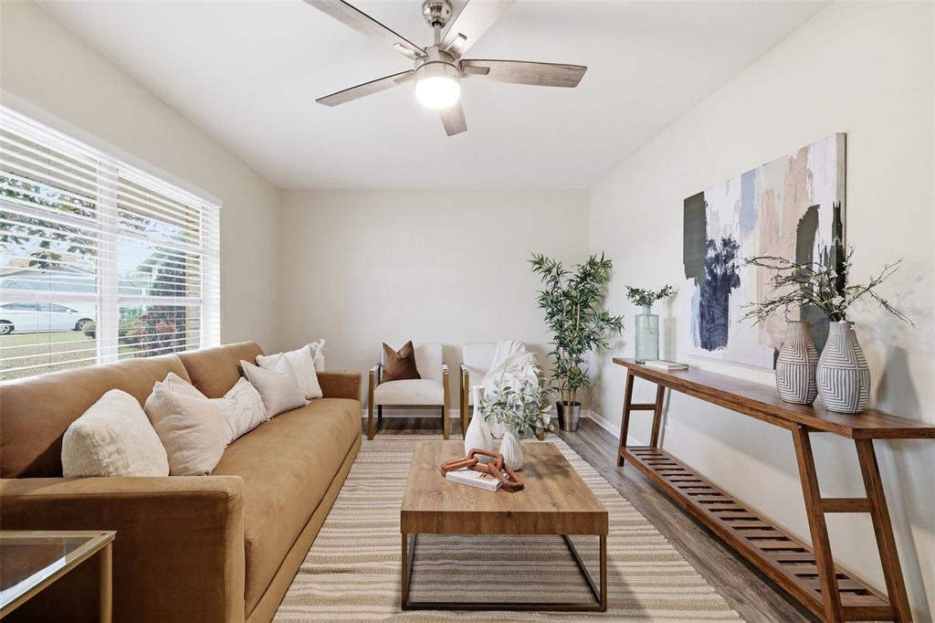 A living room features a tan sofa, wooden coffee table, console table, and ceiling fan — 2327 W KNOLLWOOD PLACE, TAMPA, FL