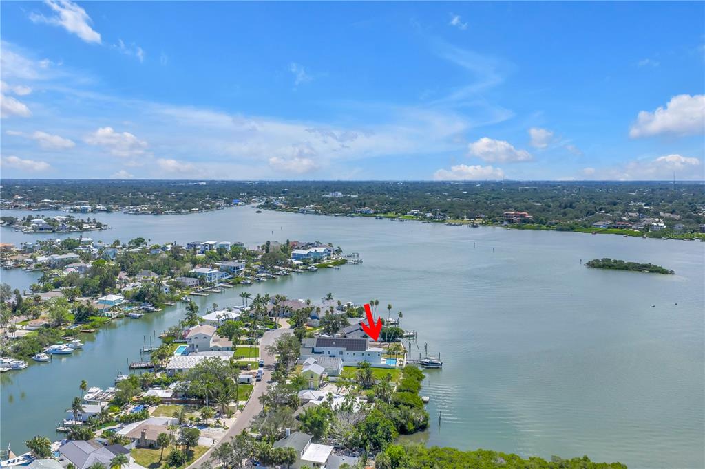 An aerial view shows a waterfront house with a pool and dock on a bay — 315 10TH AVENUE, INDIAN ROCKS BEACH, FL