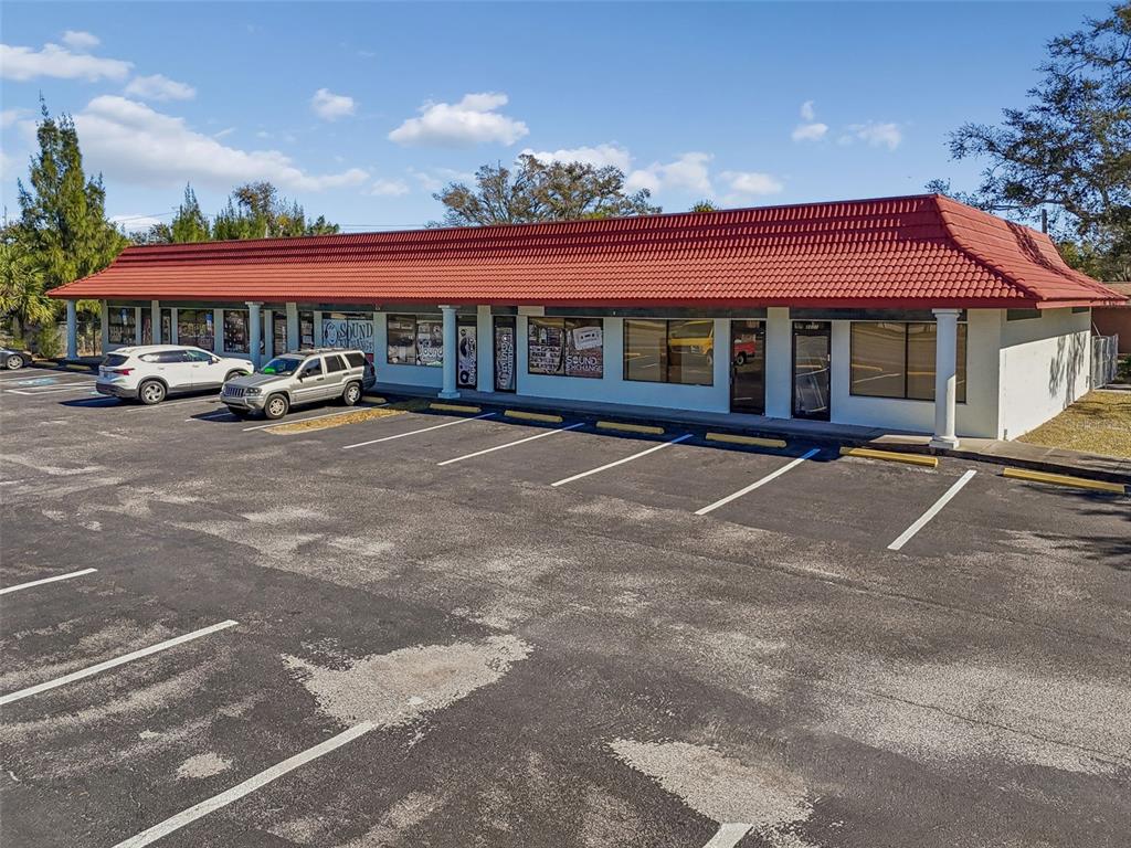 An exterior view of a single-story commercial strip mall with a red tile roof — 8625 66TH STREET N, PINELLAS PARK, FL