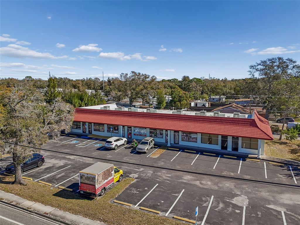 An aerial view of a single-story commercial strip mall with a red tile roof — 8625 66TH STREET N, PINELLAS PARK, FL