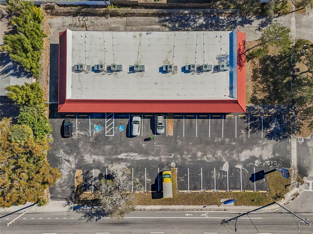 An aerial view shows a commercial building with a red roof and a parking lot — 8625 66TH STREET N, PINELLAS PARK, FL