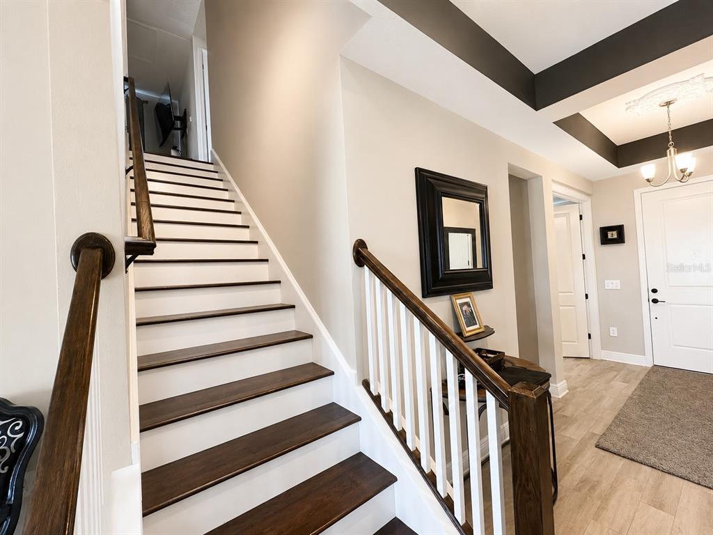 A staircase with dark wood treads and white risers leads to an upper floor — 12571 NIGHT VIEW DRIVE, SARASOTA, FL