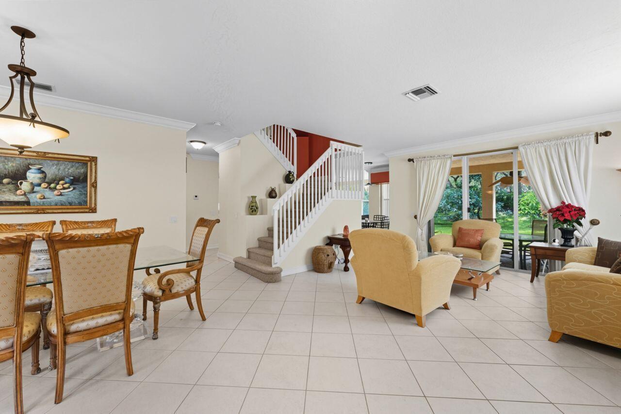 A dining area and living room with tile floors, a staircase, and sliding glass doors — 8492 Breezy Oak Way, Boynton Beach FL 33473, BOYNTON BEACH, FL