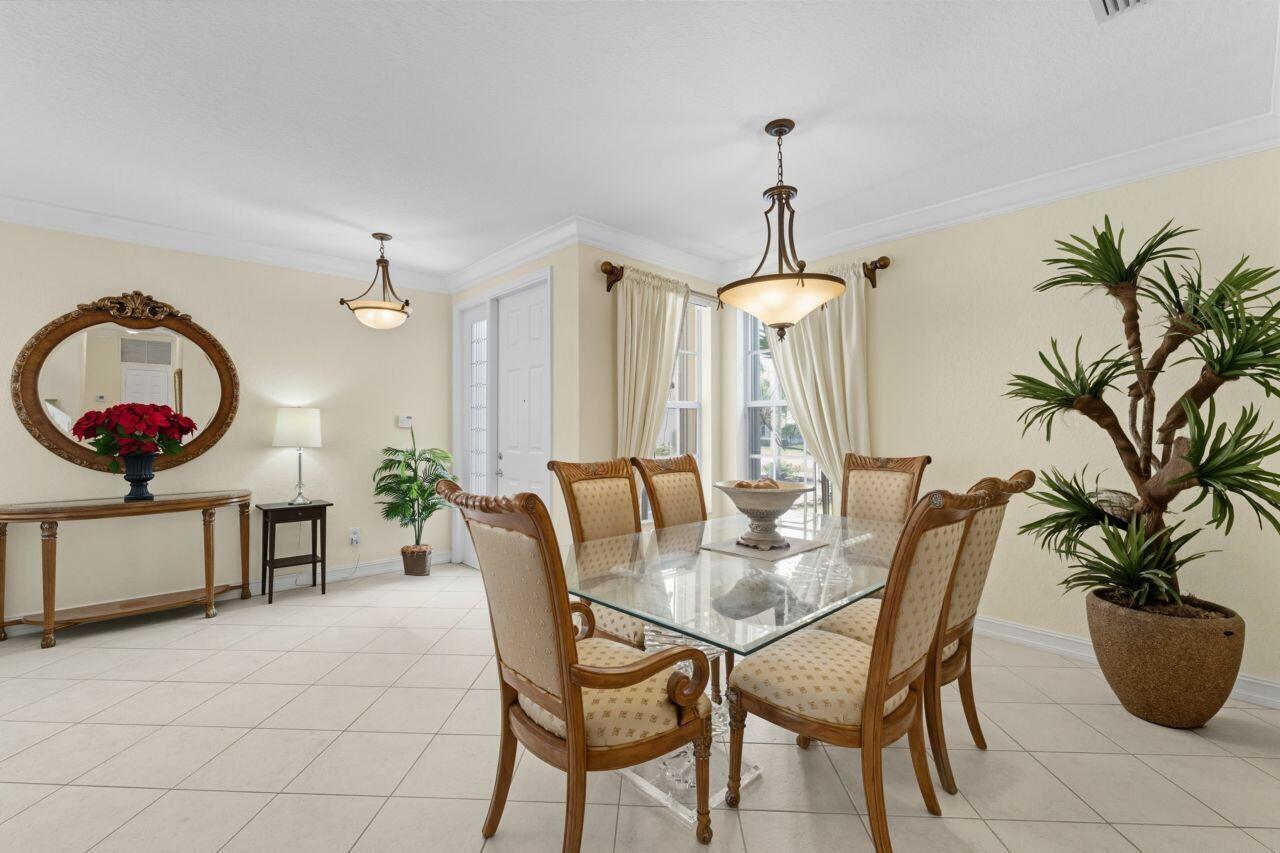 A dining room features a glass-top table, upholstered chairs, tile flooring, and two light fixtures — 8492 Breezy Oak Way, Boynton Beach FL 33473, BOYNTON BEACH, FL