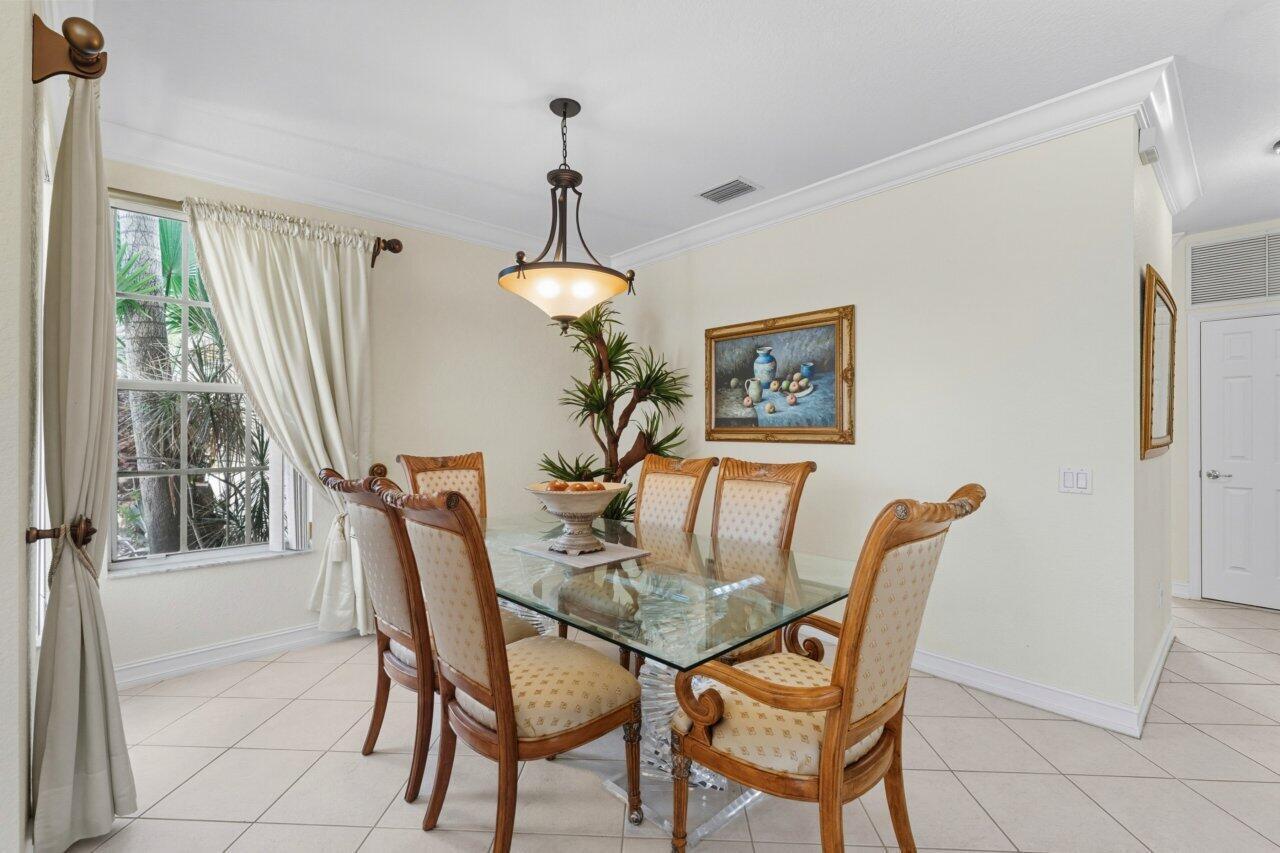 A dining room features a glass-topped table, six upholstered chairs, and a hanging light fixture — 8492 Breezy Oak Way, Boynton Beach FL 33473, BOYNTON BEACH, FL