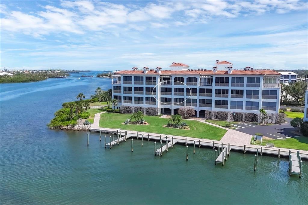 An aerial view of a multi-story waterfront condominium building with a dock and lawn — 11100 HACIENDA DEL MAR BOULEVARD UNIT G-304, PLACIDA, FL
