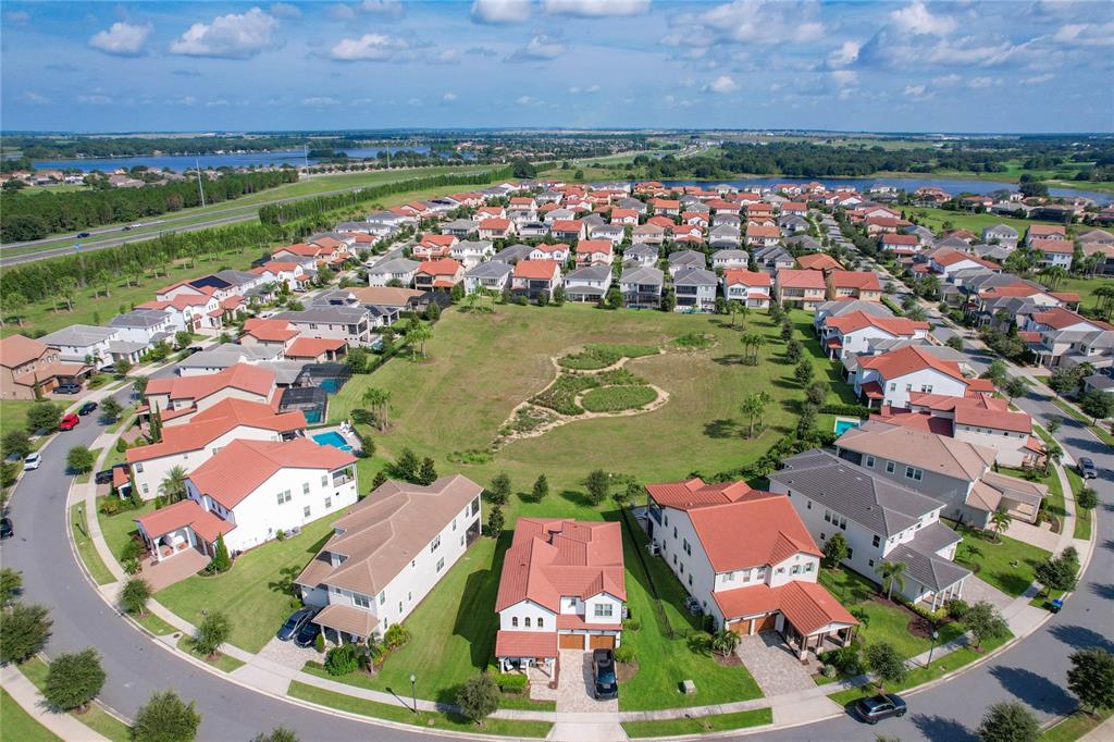 An aerial view shows a suburban neighborhood with houses surrounding a central grassy common area — 8216 TOPSAIL PLACE, WINTER GARDEN, FL