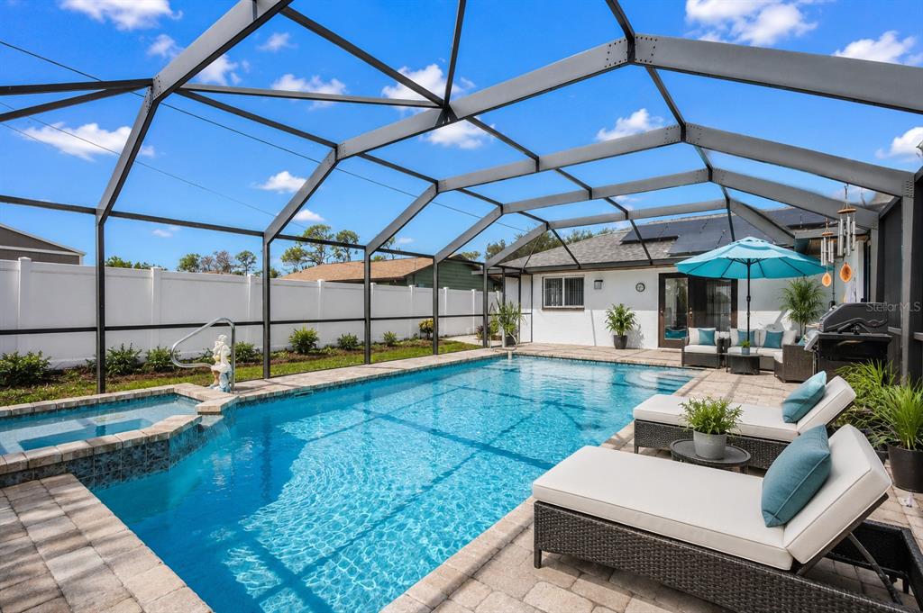 A screened-in swimming pool and spa with lounge chairs on a paved patio — 2772 AUBURN BOULEVARD, PORT CHARLOTTE, FL