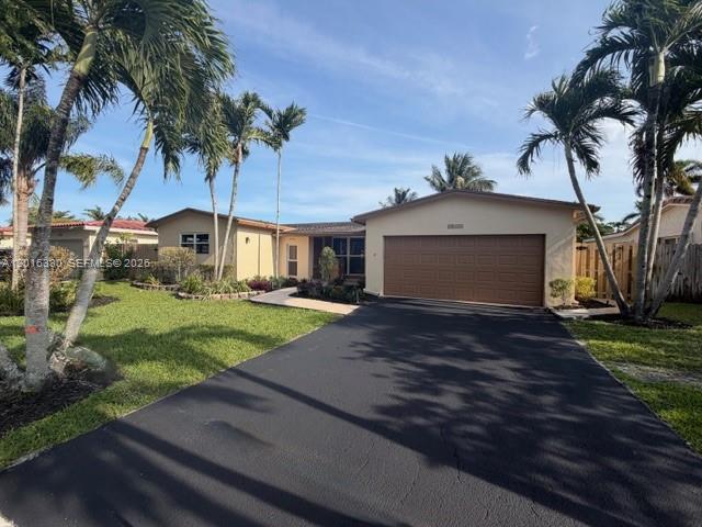 A single-story house with a large garage, a paved driveway, and several palm trees — 10524 NW 4th St, Plantation FL 33324, PLANTATION, FL
