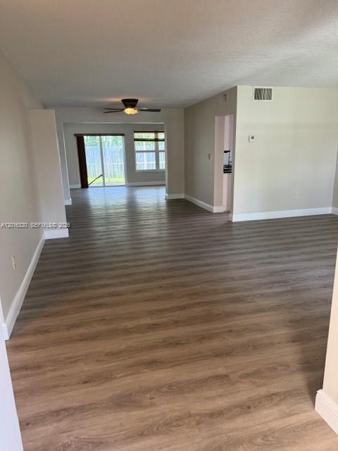 An open-concept living area features light wood-look flooring, a ceiling fan, and sliding glass doors — 10524 NW 4th St, Plantation FL 33324, PLANTATION, FL