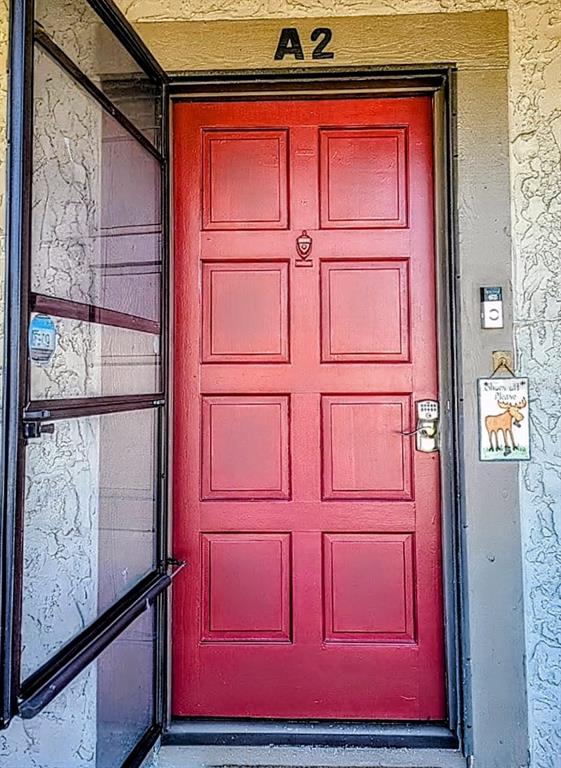 A red front door with a screen door and a moose sign at an apartment entrance — 6328 NEWTOWN CIRCLE UNIT 28A2, TAMPA, FL