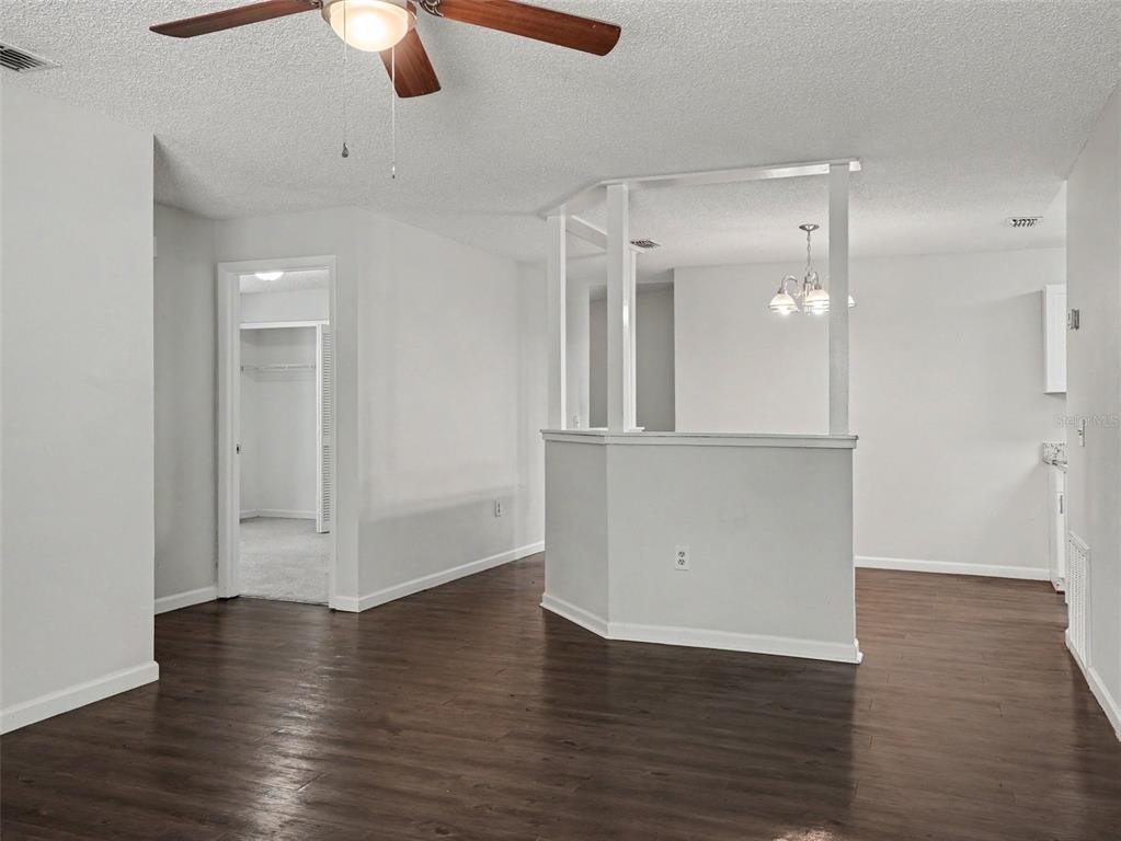 An interior view of a room with dark wood-look flooring and a half-wall partition — 406 LAKE DAISY DRIVE, WINTER HAVEN, FL