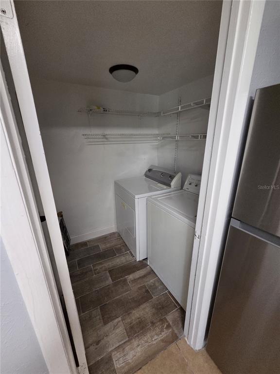 A laundry closet with a washer, dryer, and wire shelving above a tiled floor — 3976 CRAYRICH CIRCLE UNIT C1, ORLANDO, FL