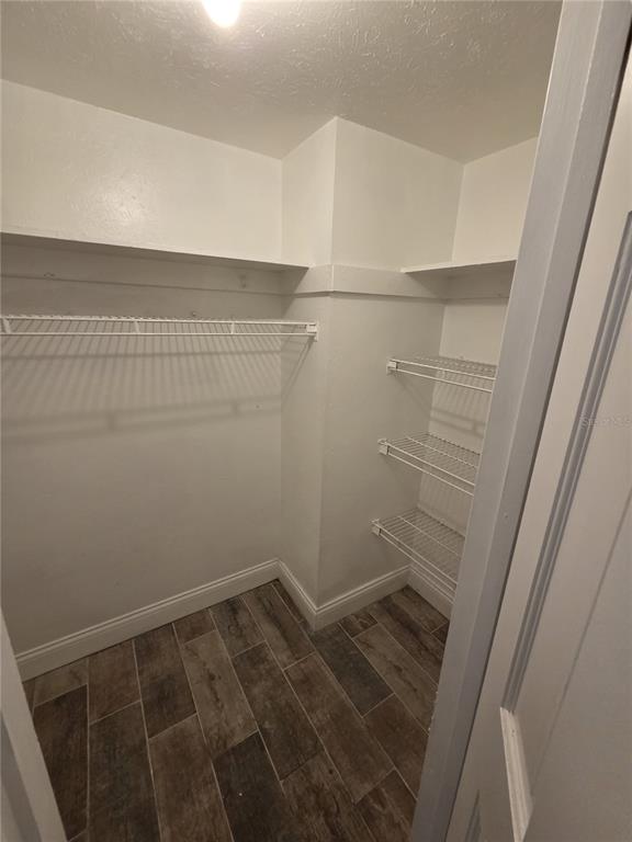 A walk-in closet with white walls, wire shelving, and wood-look tile flooring — 3976 CRAYRICH CIRCLE UNIT C1, ORLANDO, FL