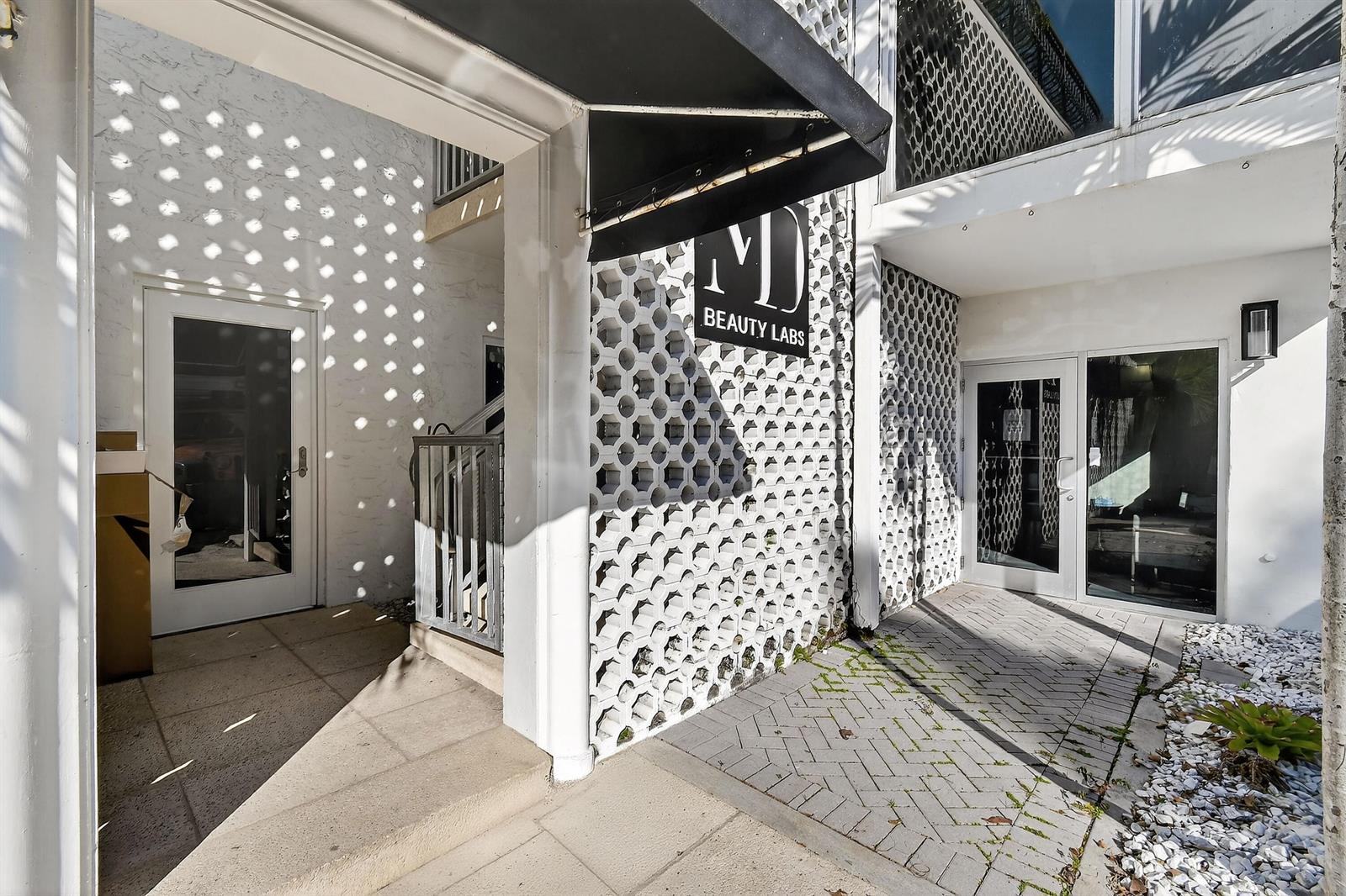 The exterior of a building features a white breeze block wall and a black awning — 249 Peruvian Avenue # 1811, Palm Beach FL 33480, PALM BEACH, FL
