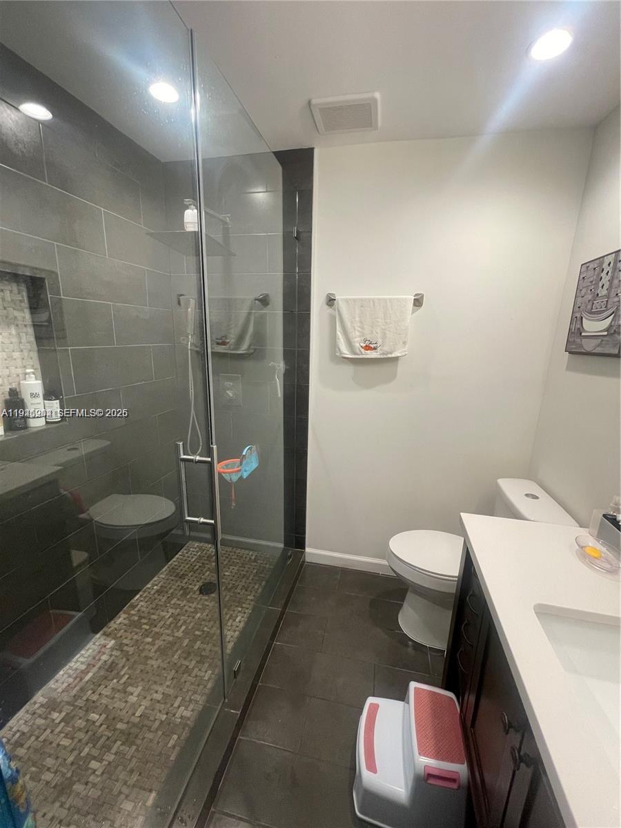 A bathroom features a glass-enclosed walk-in shower with gray tile and a dark wood vanity — 2730 Adams St, Hollywood FL 33020, HOLLYWOOD, FL