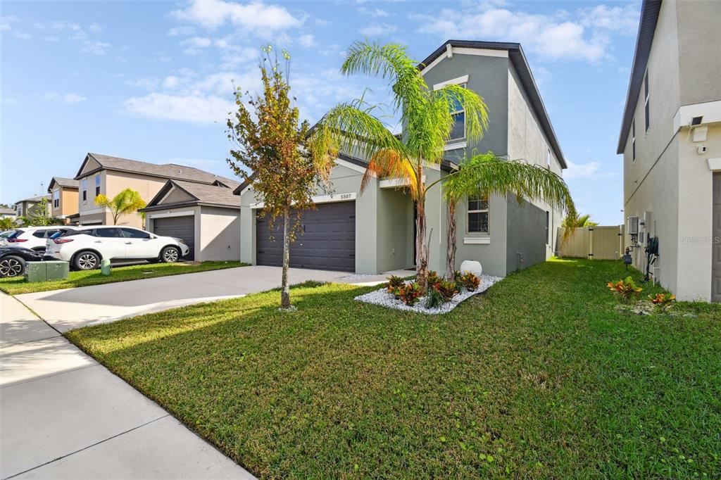 A two-story house with a gray exterior, a two-car garage, and a palm tree — 5507 RAINWOOD MEADOWS DRIVE, APOLLO BEACH, FL