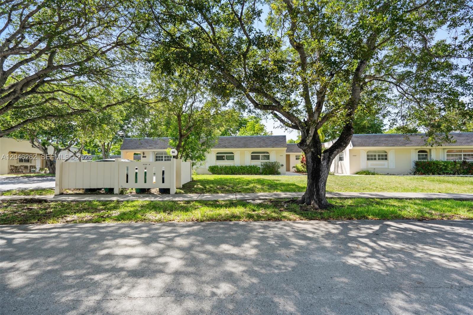 A single-story house with a white fence and large trees in the front yard — 17244 SW 112th Pl # 21342, Miami FL 33157, MIAMI, FL