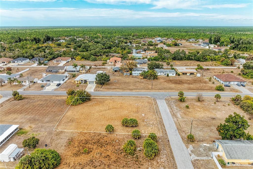 An aerial view shows a vacant, rectangular residential lot bordered by a road and vegetation — Lot 1, 2, 3 DE LEON DRIVE, NORTH PORT, FL