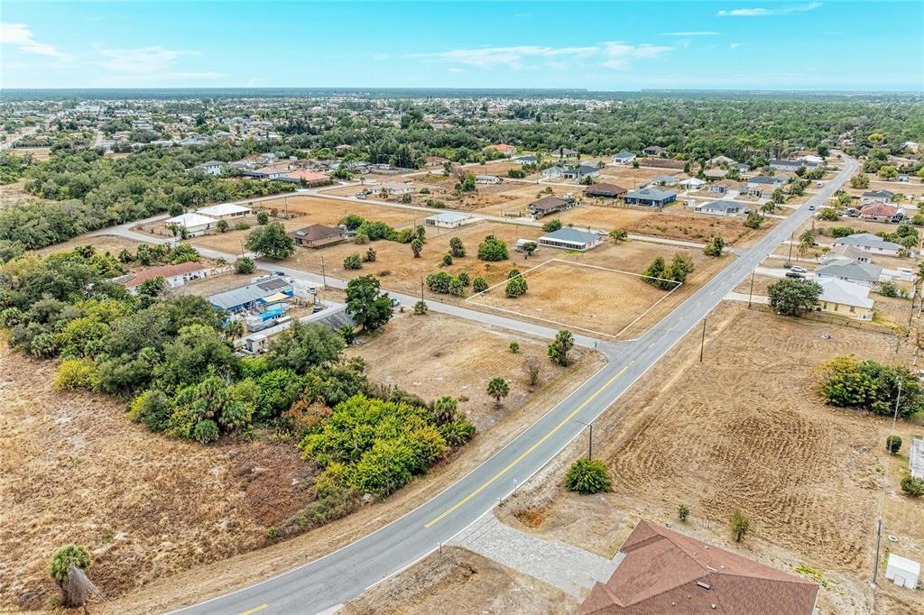 An aerial view shows a vacant residential lot bordered by a paved road and houses — Lot 1, 2, 3 DE LEON DRIVE, NORTH PORT, FL
