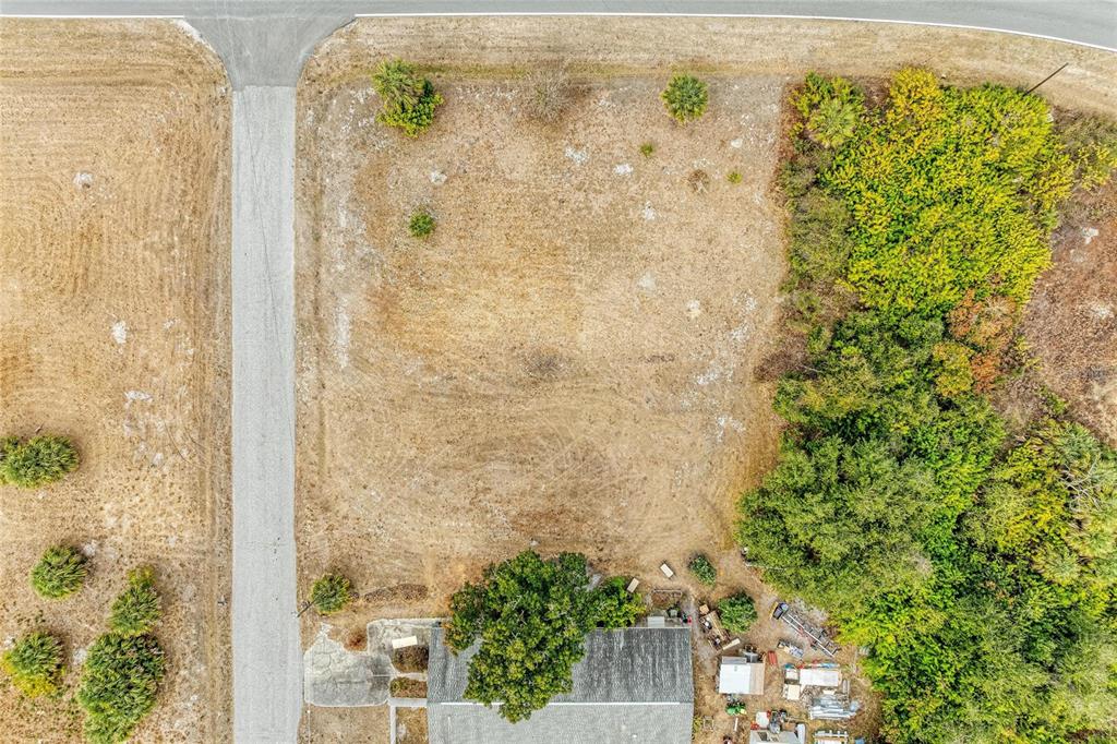 An aerial view shows a rectangular, cleared lot adjacent to a road and wooded area — Lot 1, 2, 3 DE LEON DRIVE, NORTH PORT, FL