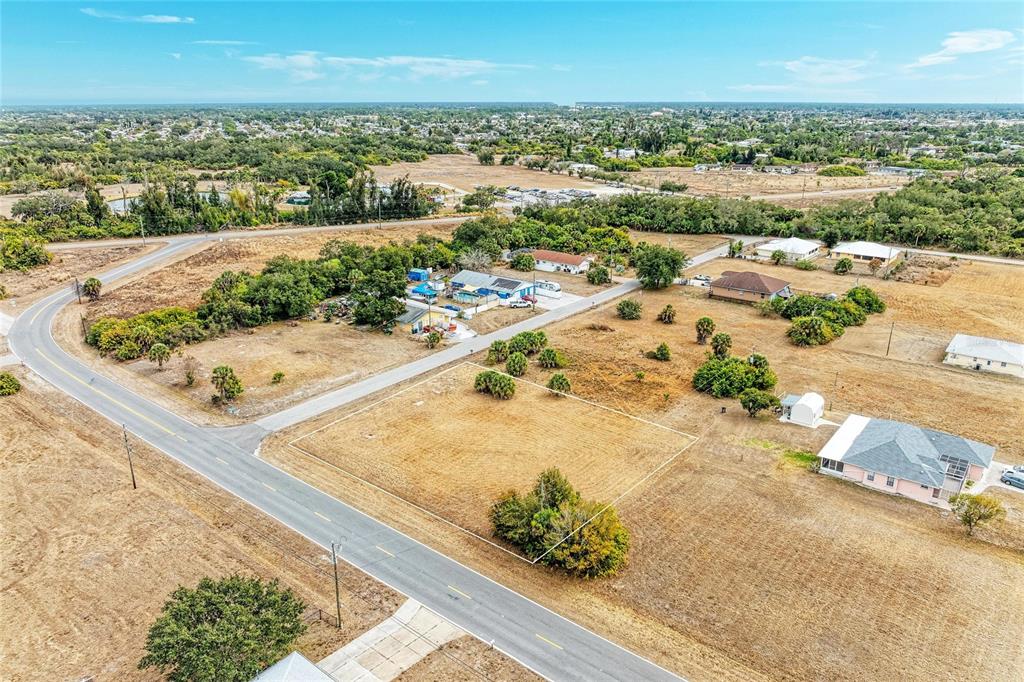 An aerial view shows a vacant, rectangular lot outlined in white next to a paved road — Lot 1, 2, 3 DE LEON DRIVE, NORTH PORT, FL