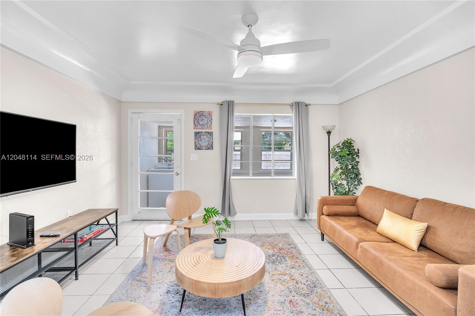 A living room features a tan leather sofa, a round coffee table, and tile flooring — 261 SW 15th St # 3, Dania Beach FL 33004, DANIA BEACH, FL