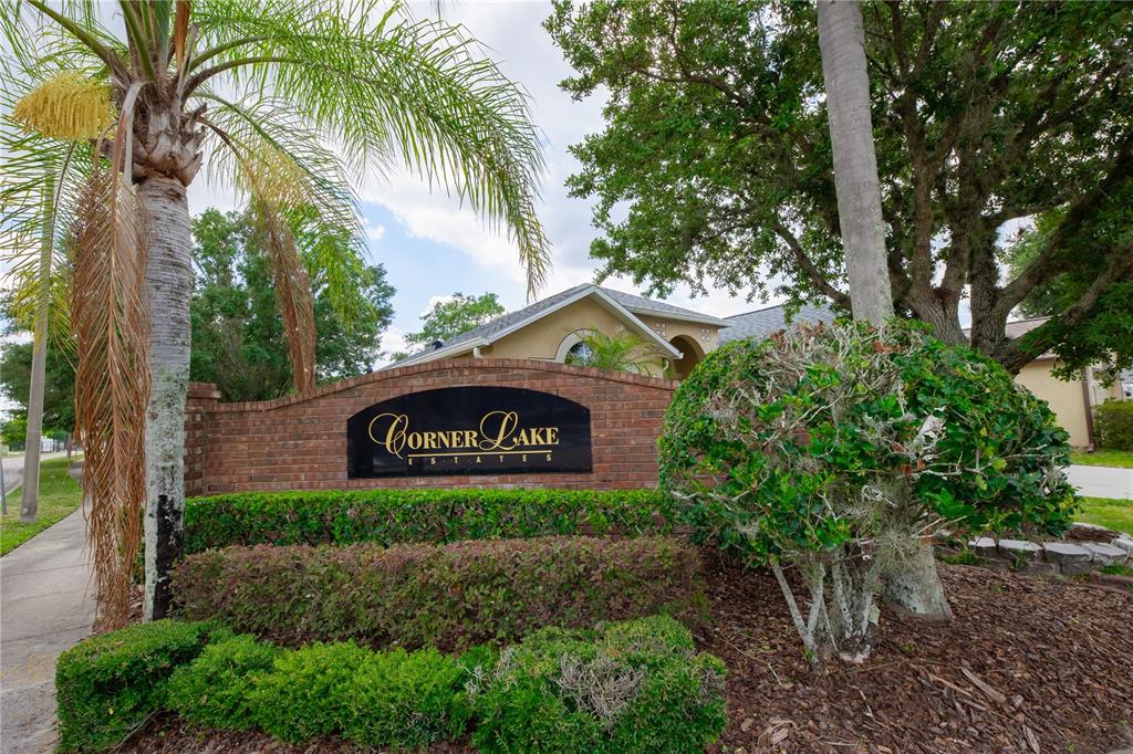 A brick monument sign for Corner Lake Estates stands in front of a residential house — 16686 CORNER COVE WAY, ORLANDO, FL