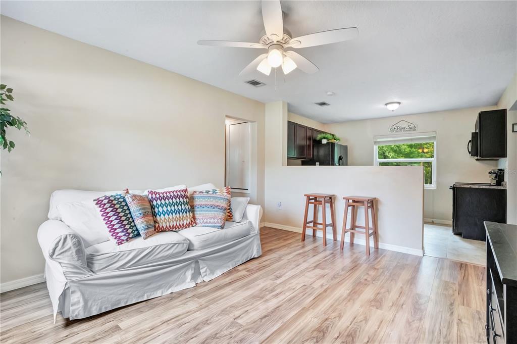 A kitchen features dark wood cabinets, laminate countertops, a black refrigerator, and tile flooring — 4901 BRISTOL COURT, ORLANDO, FL