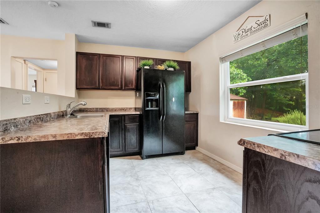 A bedroom features light wood furniture, a ceiling fan, white closet doors, and wood-look flooring — 4901 BRISTOL COURT, ORLANDO, FL