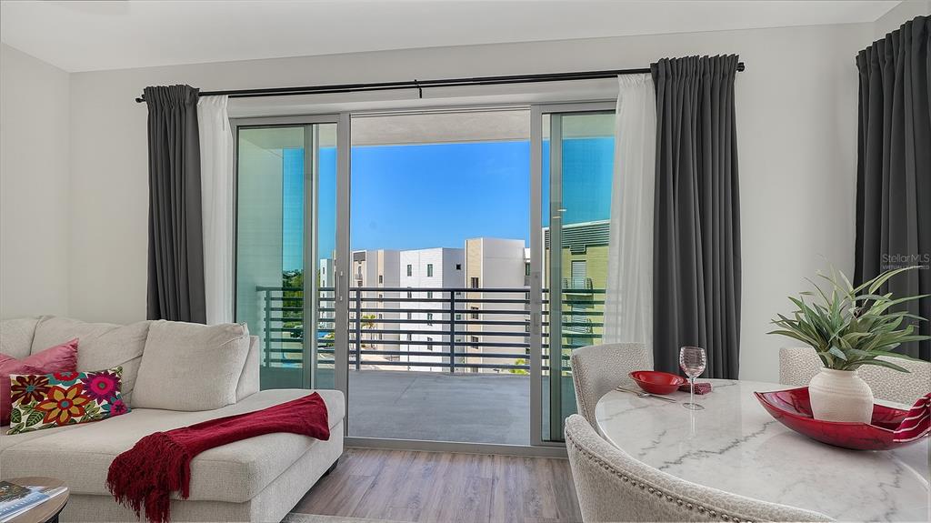 A living and dining area features a sliding glass door opening to a balcony view — 1703 N TAMIAMI TRAIL UNIT 511, SARASOTA, FL