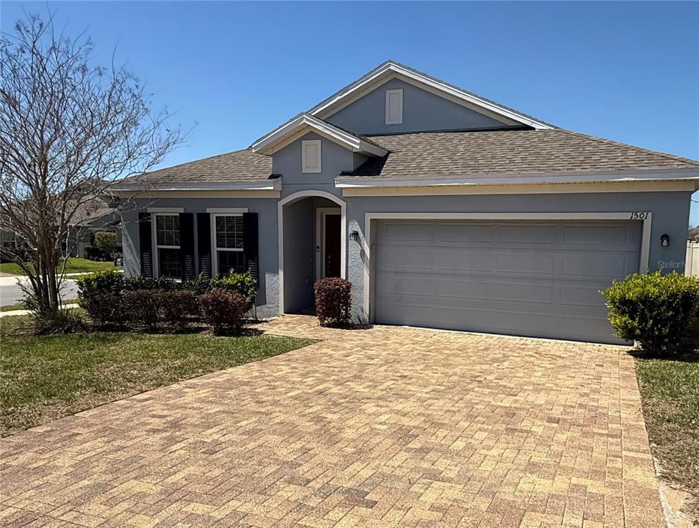 A single-story house with a gray exterior, a two-car garage, and a paved driveway — 1501 FINCHBURG STREET, MINNEOLA, FL