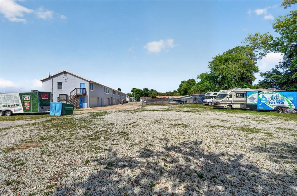 A gravel lot features a long, light-colored building and two parked commercial trailers — 468 RIDGEWOOD AVENUE, DAYTONA BEACH, FL