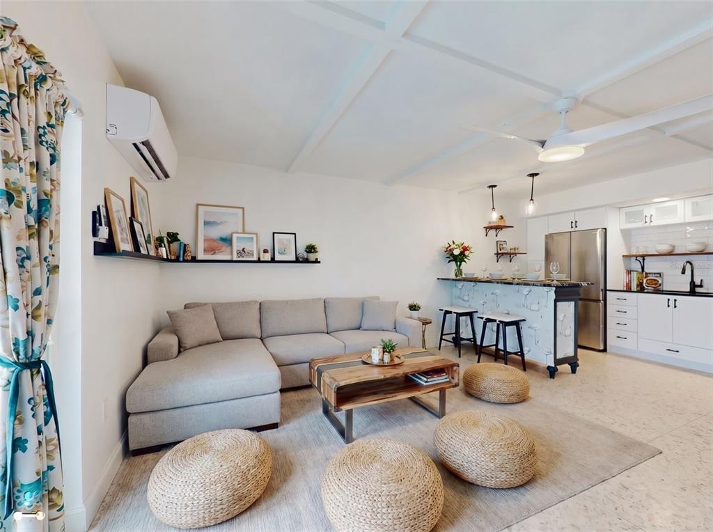 A living room with a sectional sofa, coffee table, and open kitchen with a breakfast bar — 3700 S ATLANTIC AVENUE UNIT 207, NEW SMYRNA BEACH, FL