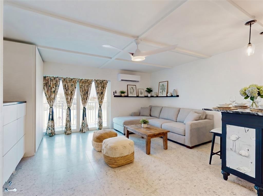 A living room features a grey sectional sofa, a wooden coffee table, and patterned curtains — 3700 S ATLANTIC AVENUE UNIT 207, NEW SMYRNA BEACH, FL
