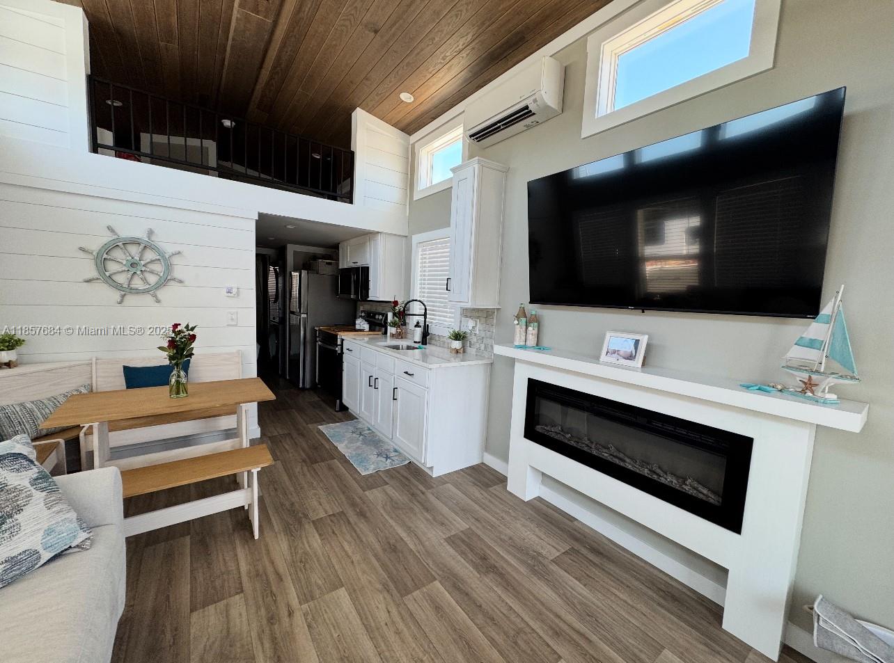 This living area features a fireplace, a mounted television, a kitchen, and a loft space — 325 Calusa St 302, Key Largo FL 33037, KEY LARGO, FL