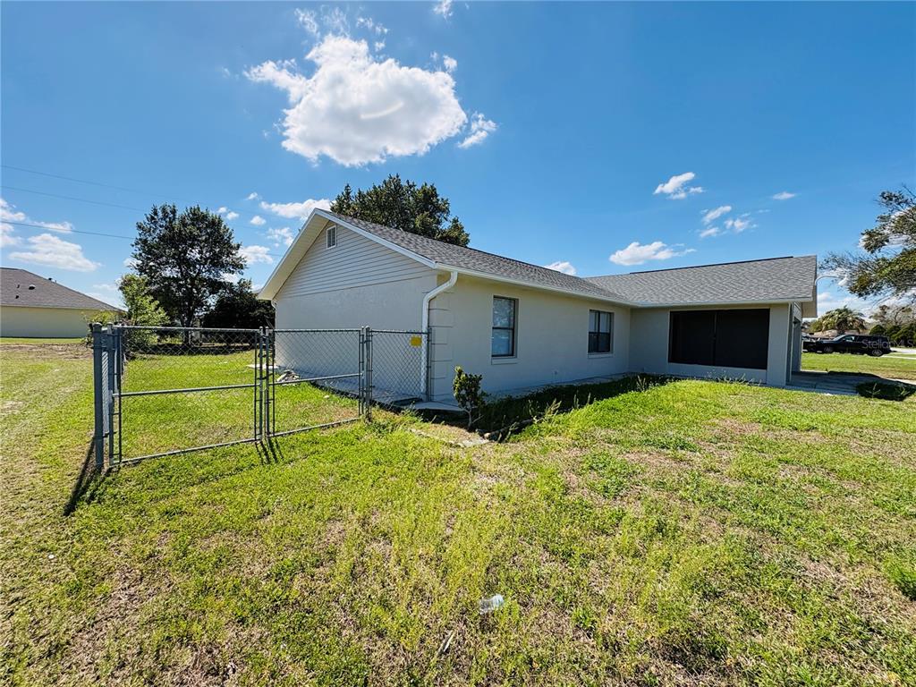 A side view of a single-story house with a fenced yard and a screened porch — 2870 SW 143RD PLACE ROAD, OCALA, FL
