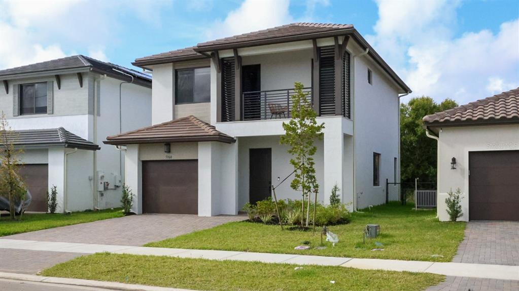 A two-story house with a brown garage door, a balcony, and a tiled roof — 5868 AGOSTINO WAY, AVE MARIA, FL
