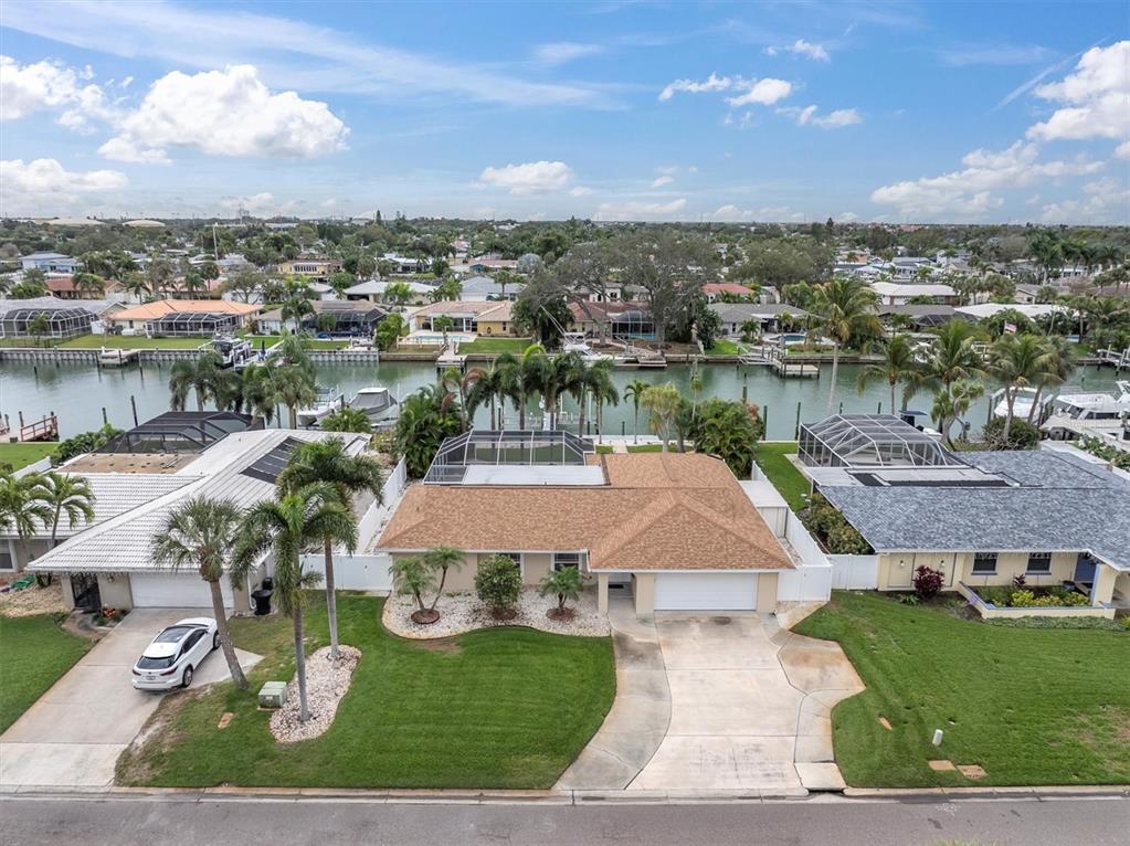 An aerial view of a single-story house with a tan roof and a canal-front backyard — 4200 46TH AVENUE S, ST PETERSBURG, FL