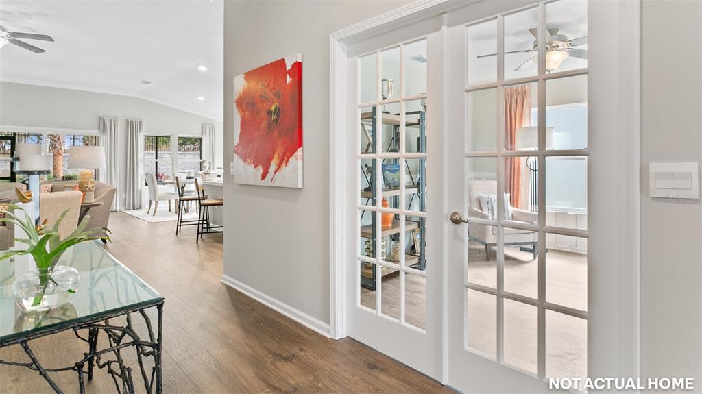 This rendering shows a hallway with a glass-topped table, abstract wall art, and French doors — 44 HARDWOOD TRAIL, PALM COAST, FL